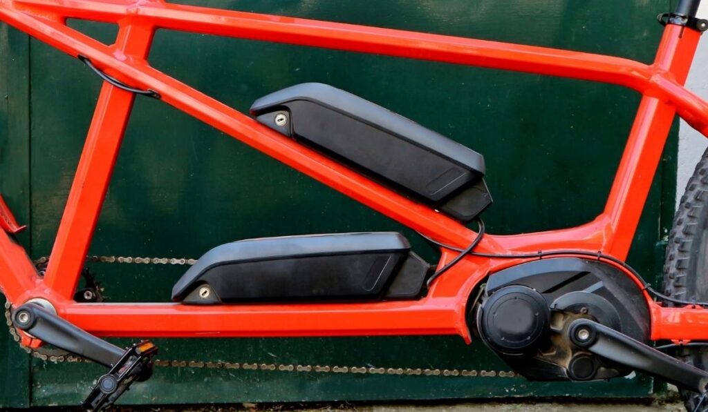 Electric tandem bicycle. Details of the double battery on the chassis and engine