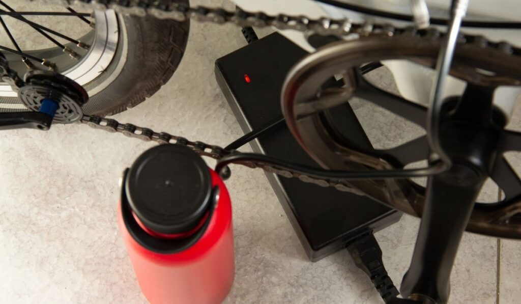 An electric charger whose light is red, a sign that it is charging an electric bicycle