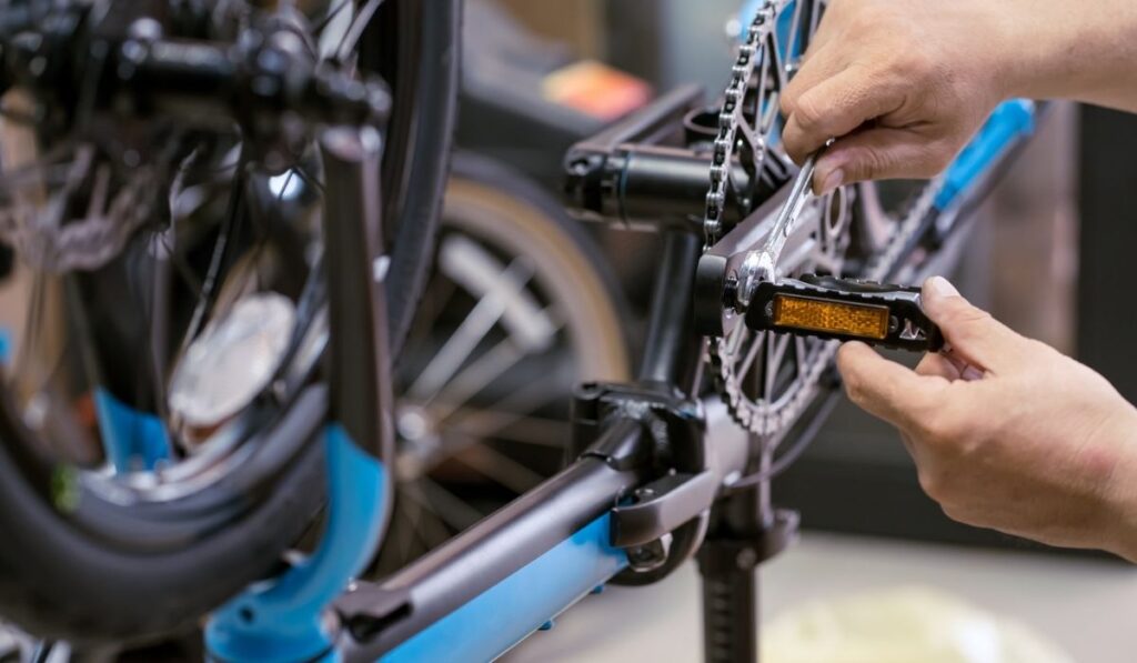 Bike mechanic repairs folding bicycle in Workshop 