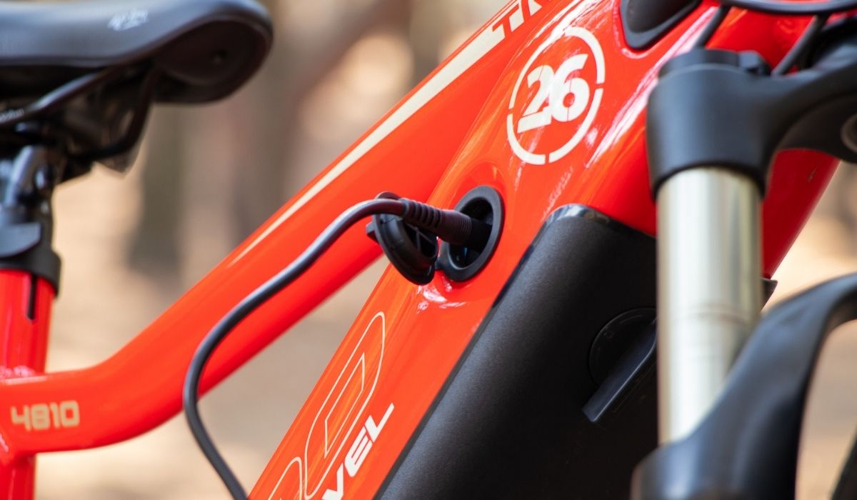 Red electric bike with charging cable plugged in