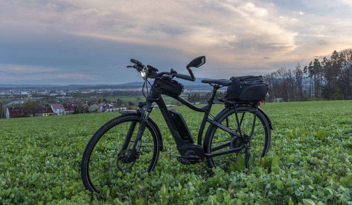Black and gray electric bicycle in sunset time with cloudy sky
