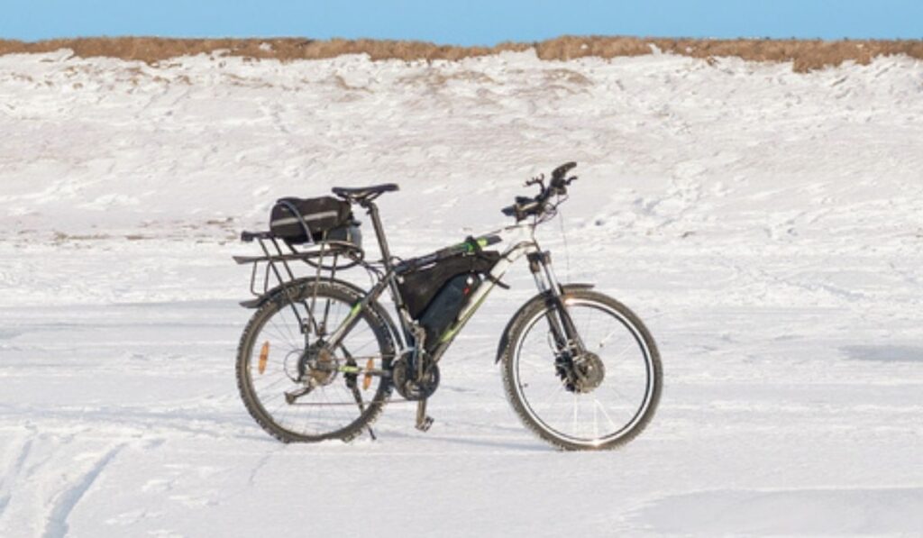 Lone electric bike on snow plain under blue sky