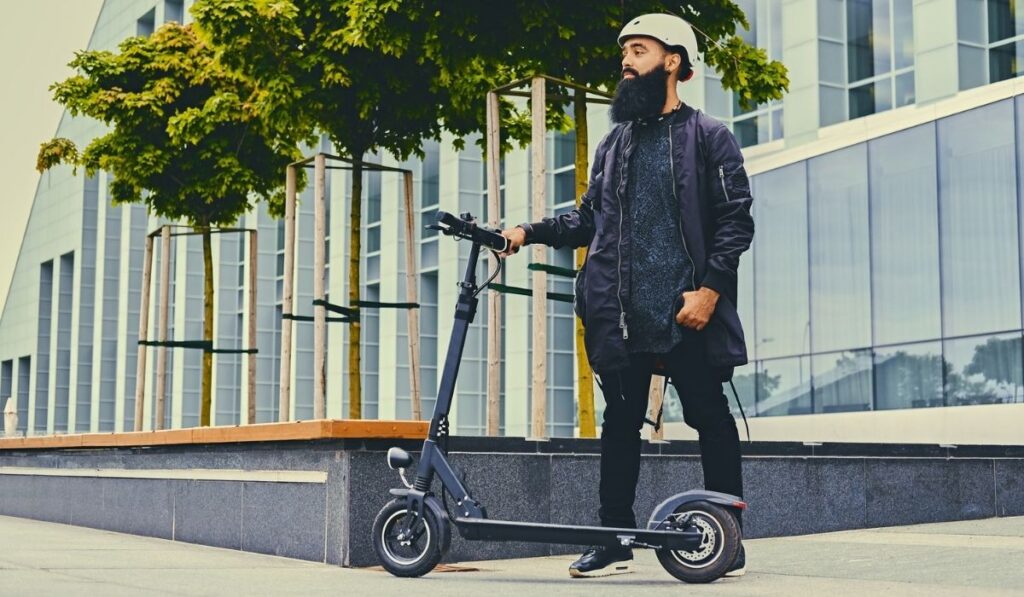 A man posing on electric scooter 