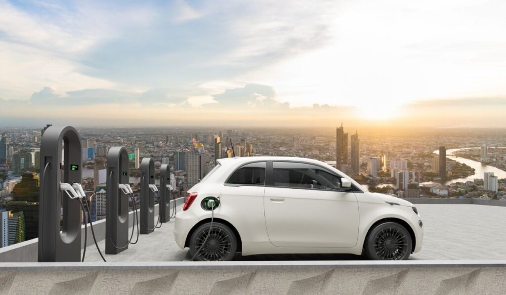 Compact electric car charging in the station of rooftop with city background