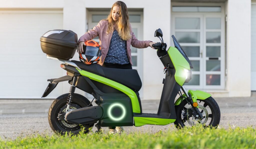 Young woman preparing her trip on electric motorcycle in the street