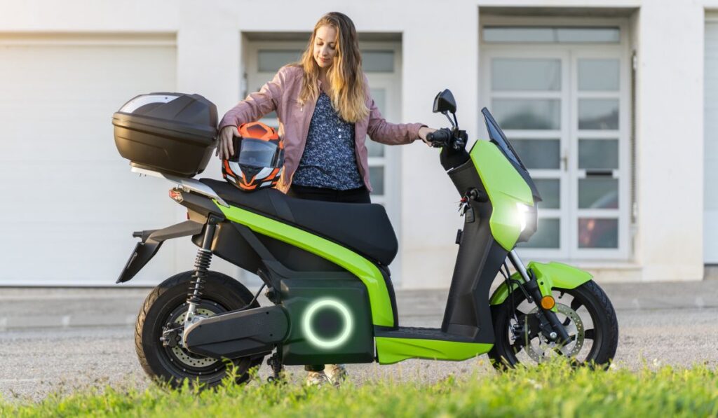 Young woman preparing her trip on electric motorcycle in the street