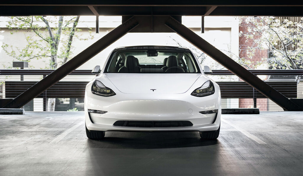 White Tesla car in parking garage